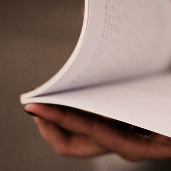 woman's hand flipping pages in a text book